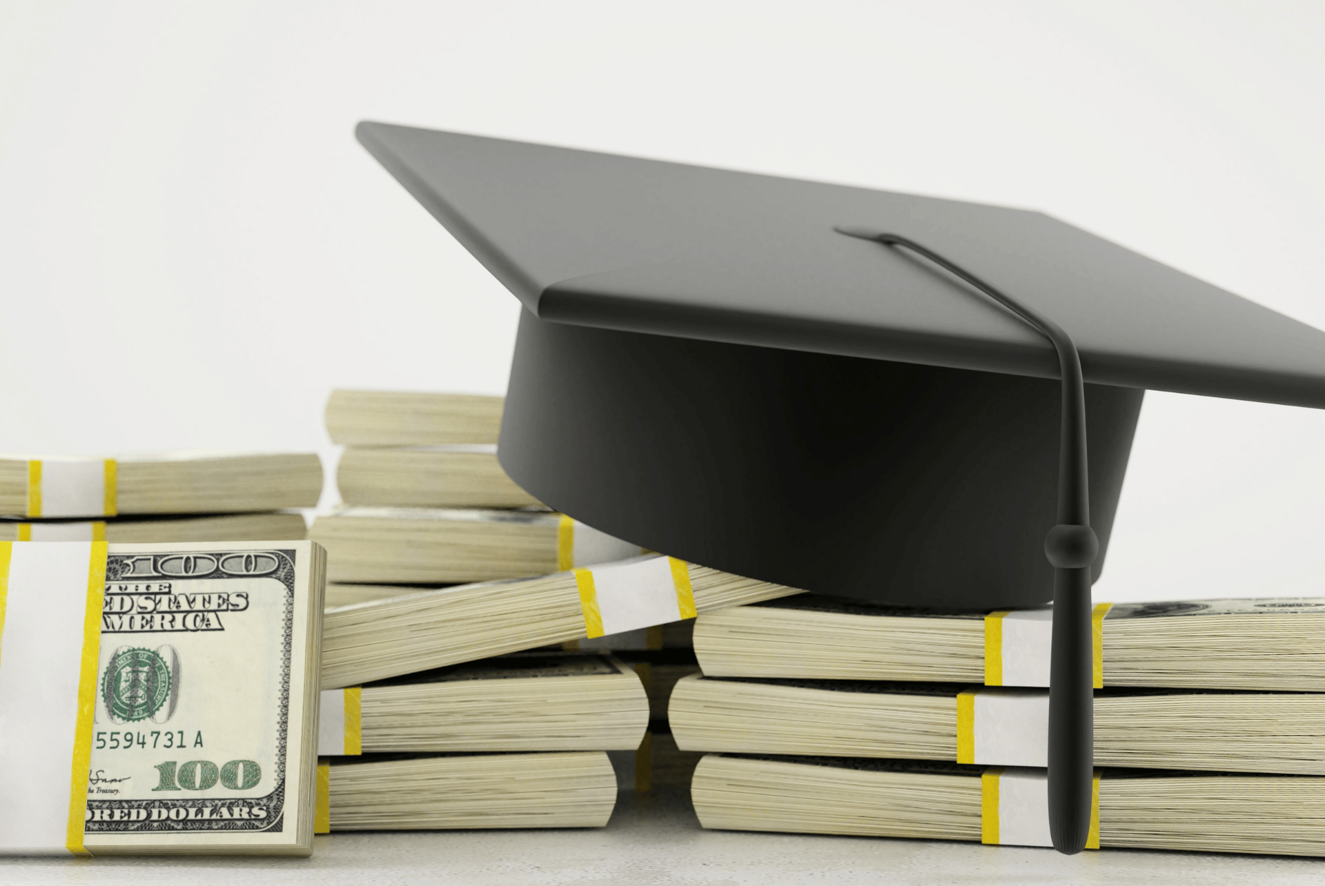 grad cap on top of a pile of money